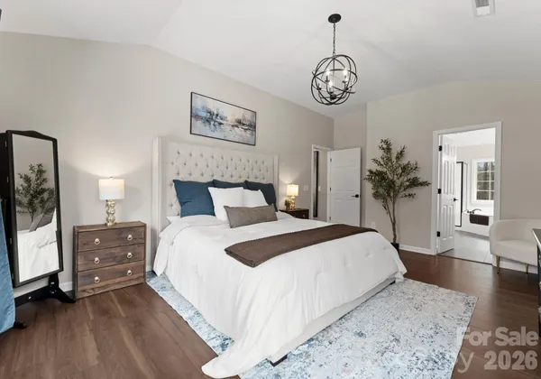 a bedroom with a large bed and a chandelier