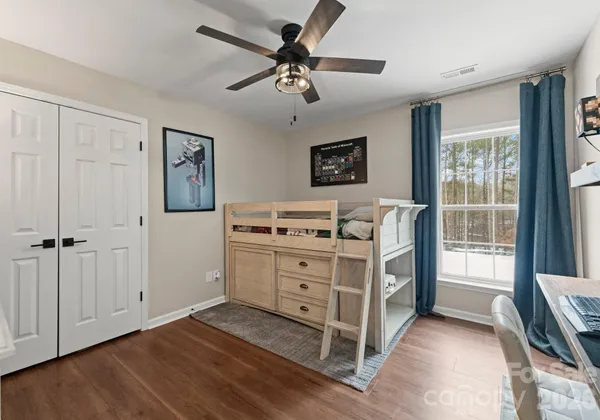 a bedroom with a bed lamp and a large window