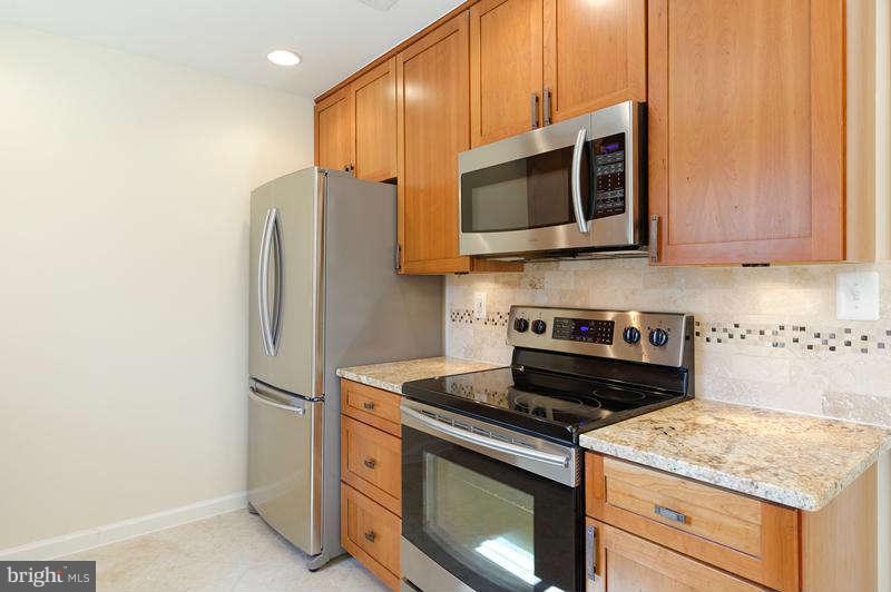 10907 Knights Bridge Court Reston, VA 20190 - Photo 8 of 24 a kitchen with stainless steel appliances granite countertop a stove microwave and refrigerator