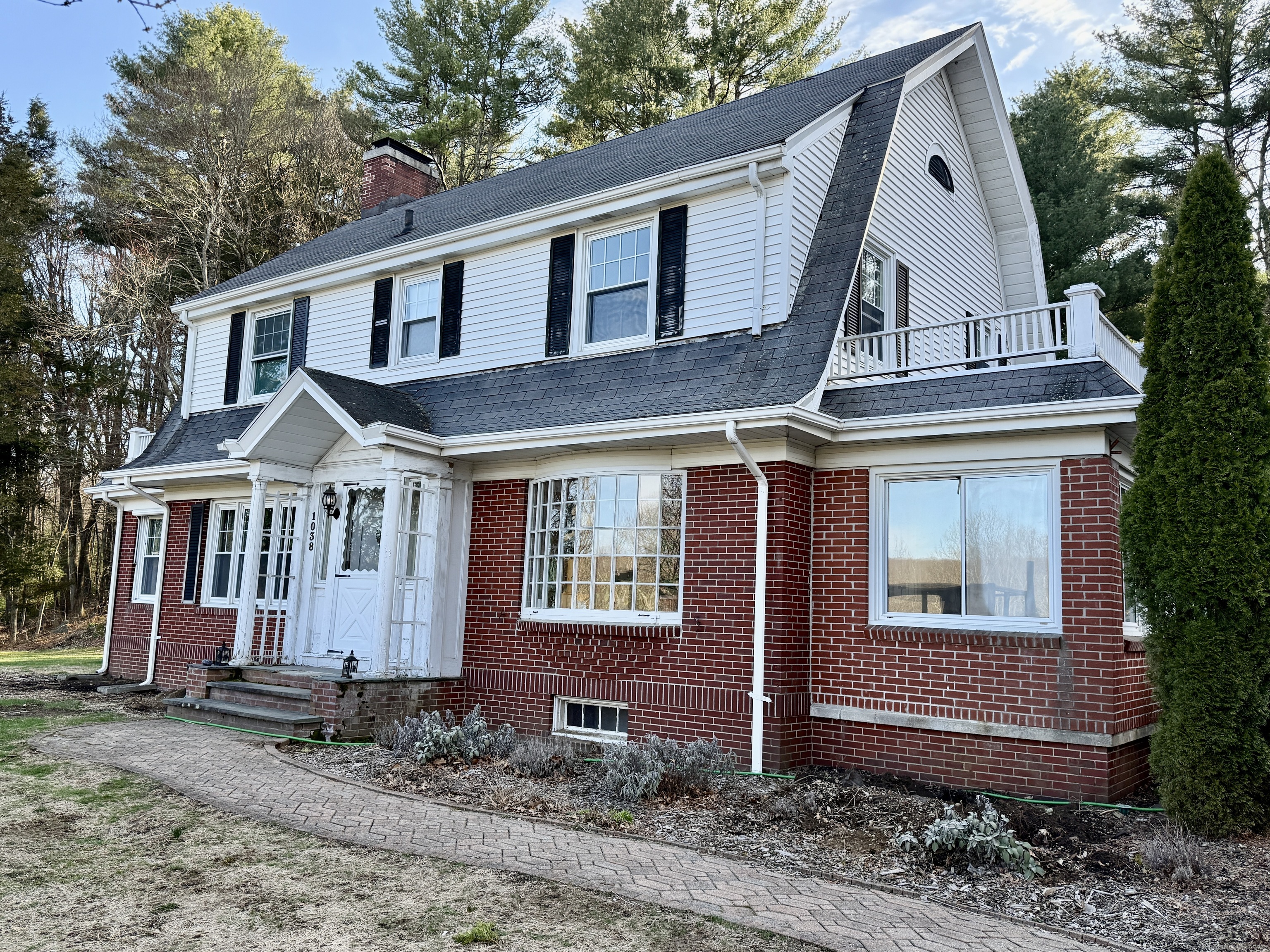 a view of a white house with large windows and a small yard