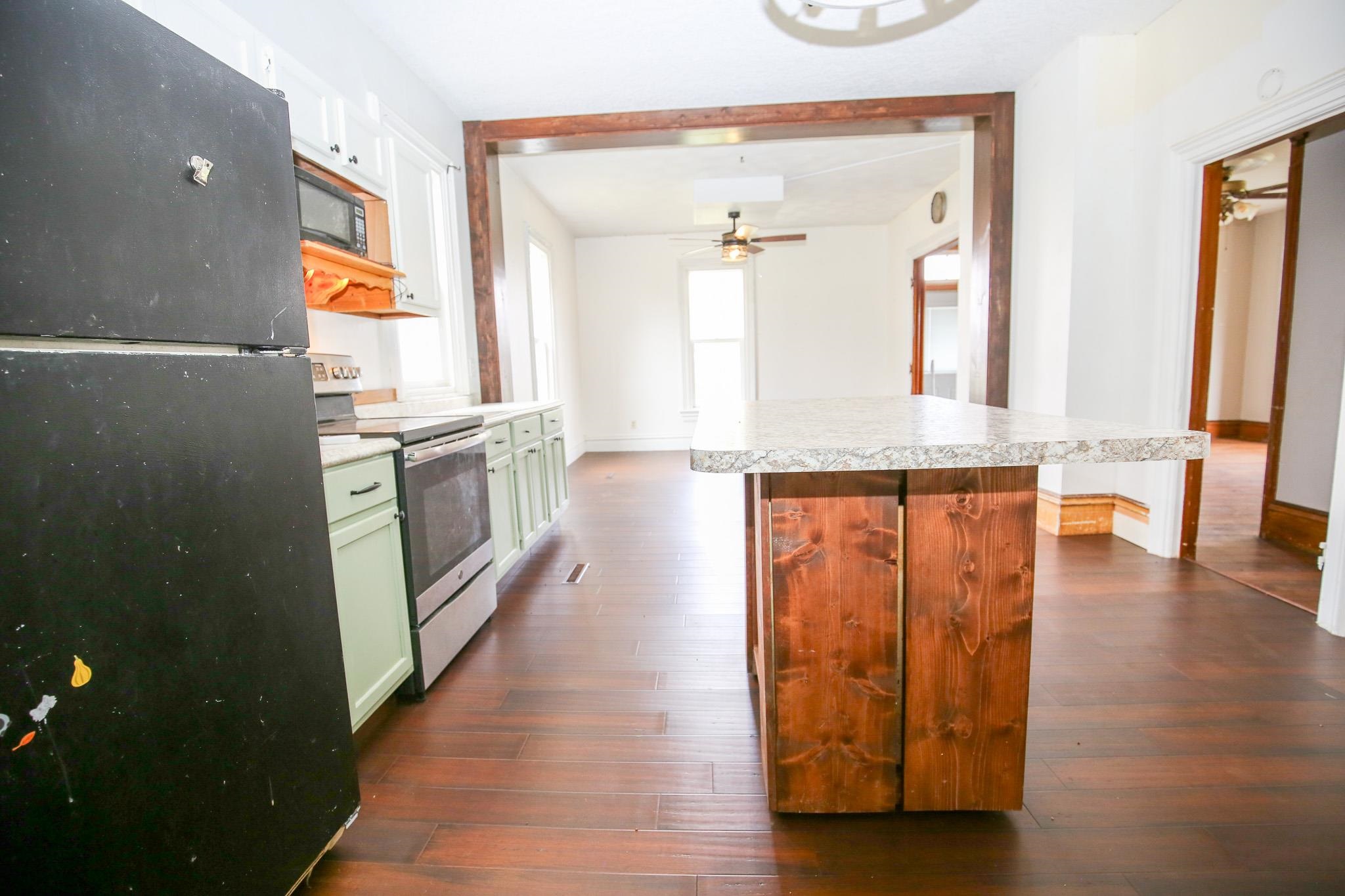 26596 Fairhaven Road Chadwick, IL 61014 - Photo 39 of 51 a hallway with stainless steel appliances granite countertop a stove and a wooden floors