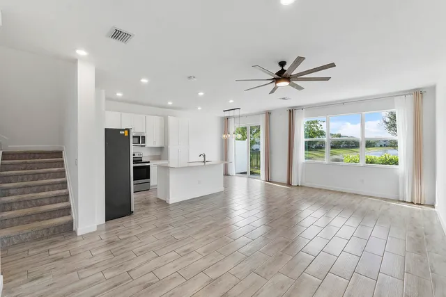 a view of a kitchen with wooden floor and a window