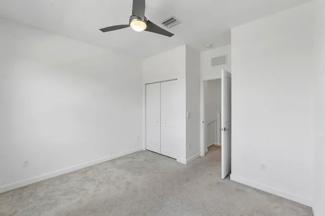 an empty room with a ceiling fan and a window