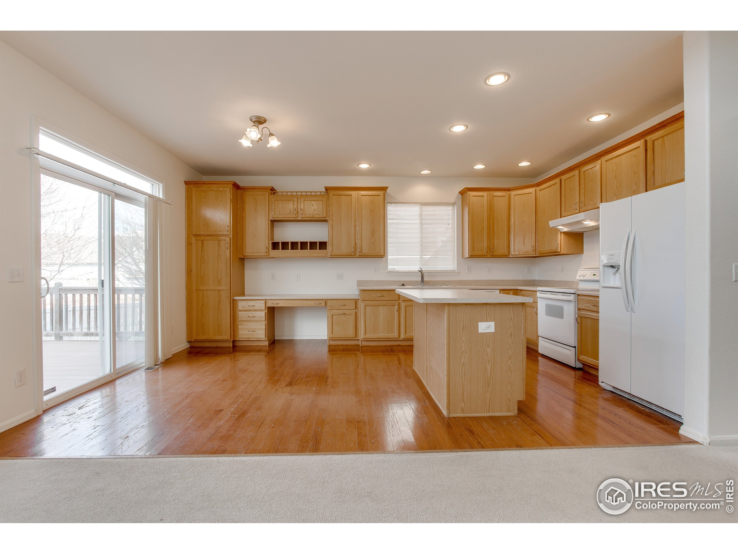 6808 Silverleaf Avenue Firestone, CO 80504 - Photo 9 of 40 a open kitchen with white cabinets and stainless steel appliances