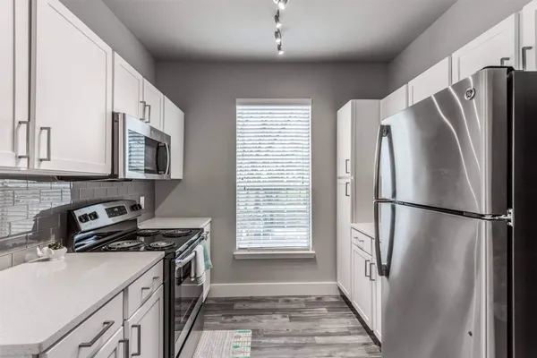 a kitchen with a refrigerator sink and cabinets