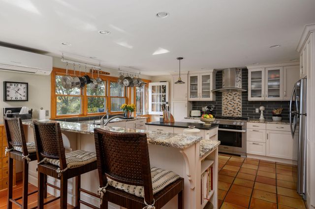 a kitchen with a table chairs microwave and cabinets