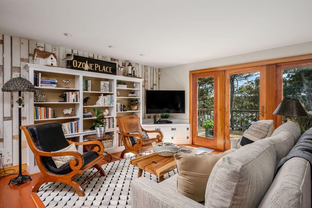 a living room with furniture a flat screen tv and a bookshelf