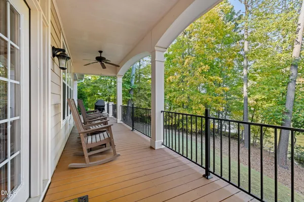 a roof deck with table and chairs under an umbrella with a wooden floor