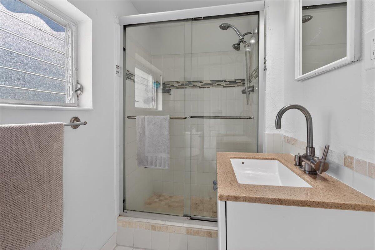 110 Northeast 30th Street Pompano Beach, FL 33064 - Photo 17 of 31 a bathroom with a granite countertop sink mirror and shower