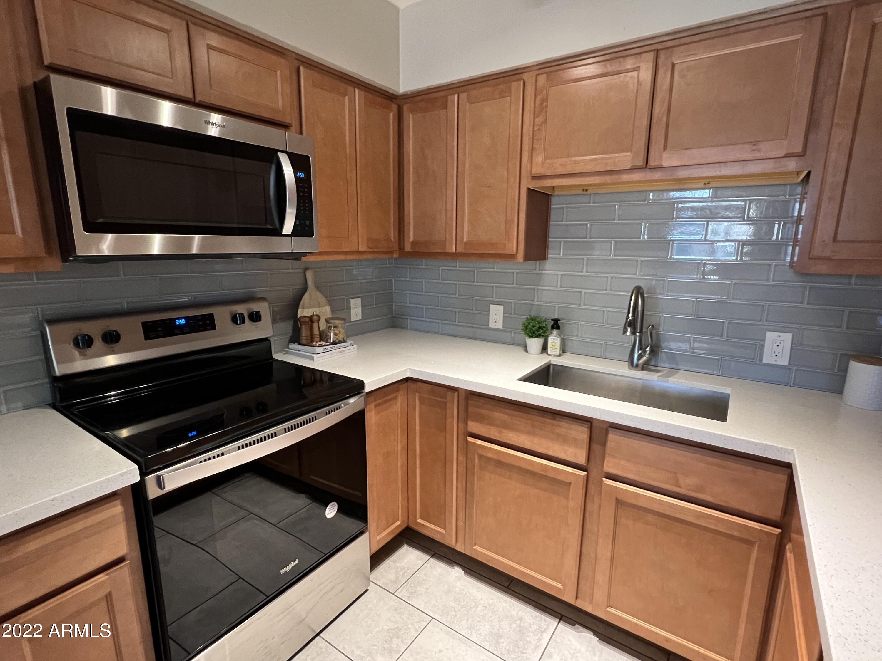 1250 East Bethany Home Road, Unit 17 Phoenix, AZ 85014 - Photo 4 of 25 a kitchen with a sink and a stove top oven