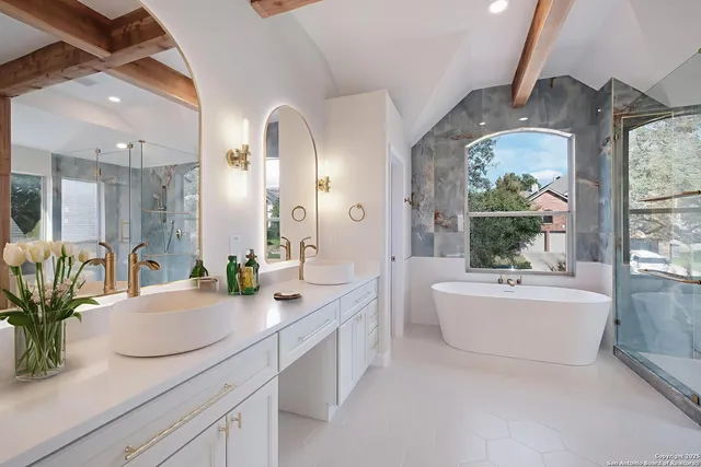 a bathroom with a granite countertop sink mirror and bathtub