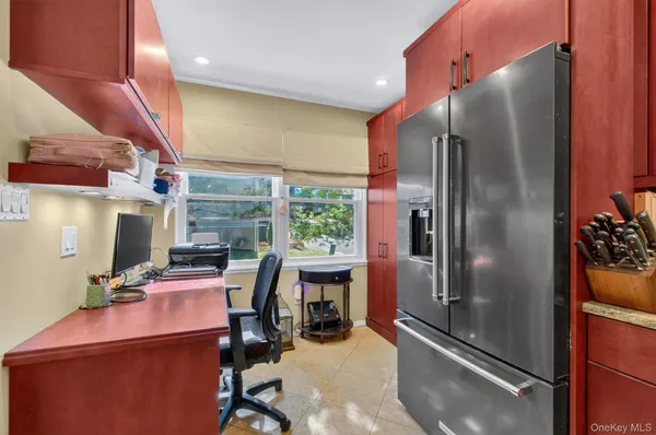 a kitchen with a refrigerator and table chairs