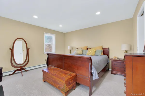 a bedroom with furniture and a mirror