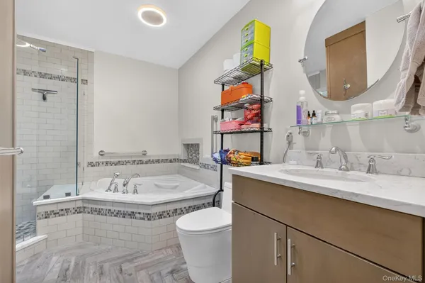 a bathroom with a granite countertop sink mirror vanity and toilet