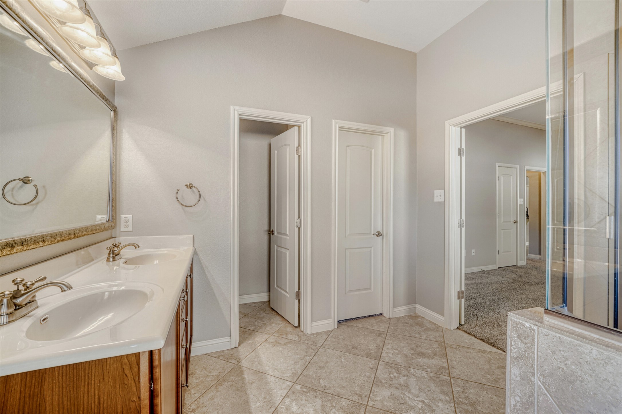 2431 Santa Barbara Loop Round Rock, TX 78665 - Photo 23 of 34 Bathroom with double vanity, vaulted ceiling, and light tile patterned floors