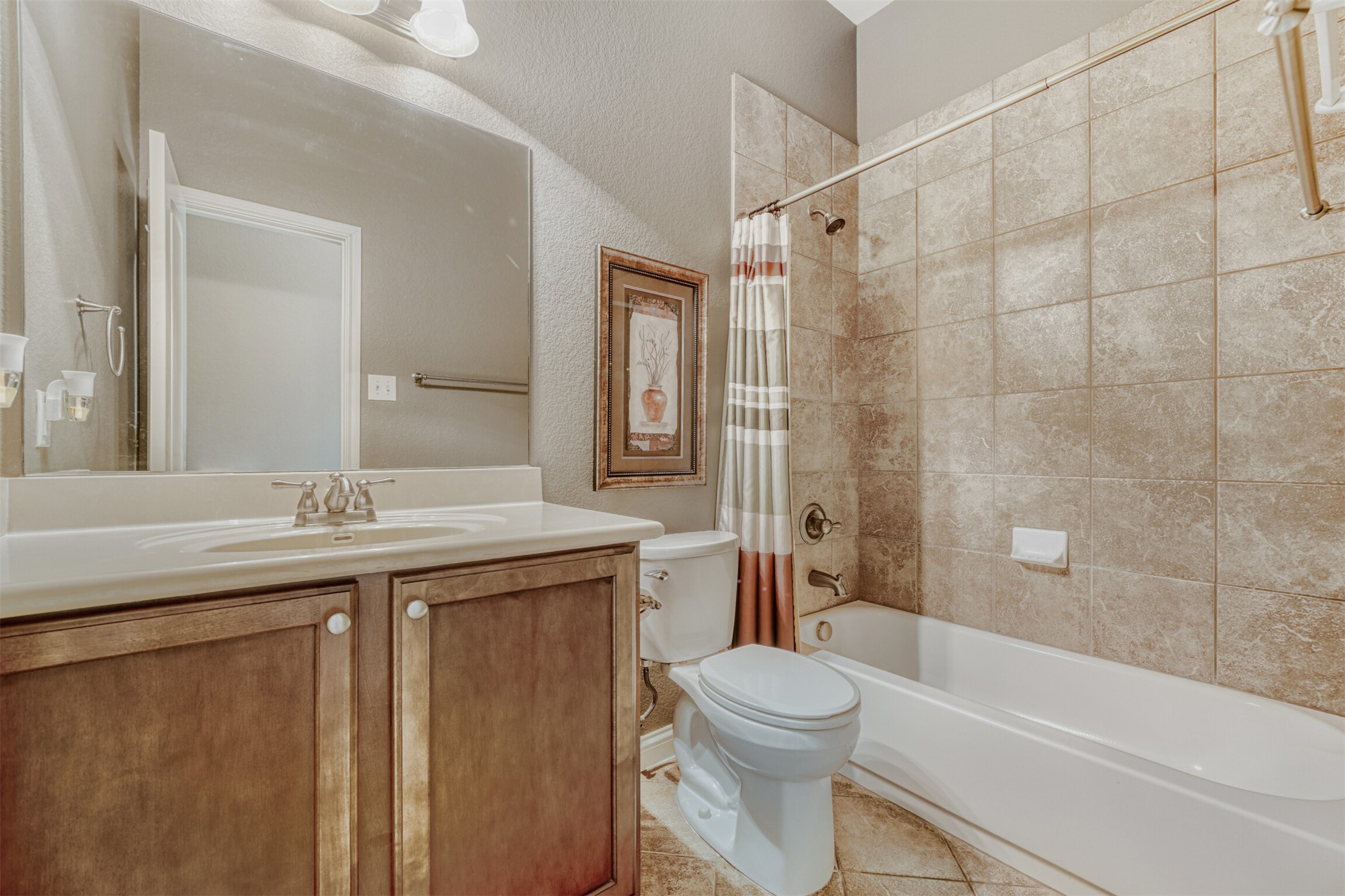 2431 Santa Barbara Loop Round Rock, TX 78665 - Photo 24 of 34 Full bathroom featuring a textured wall, shower / tub combo, vanity, and light tile patterned floors