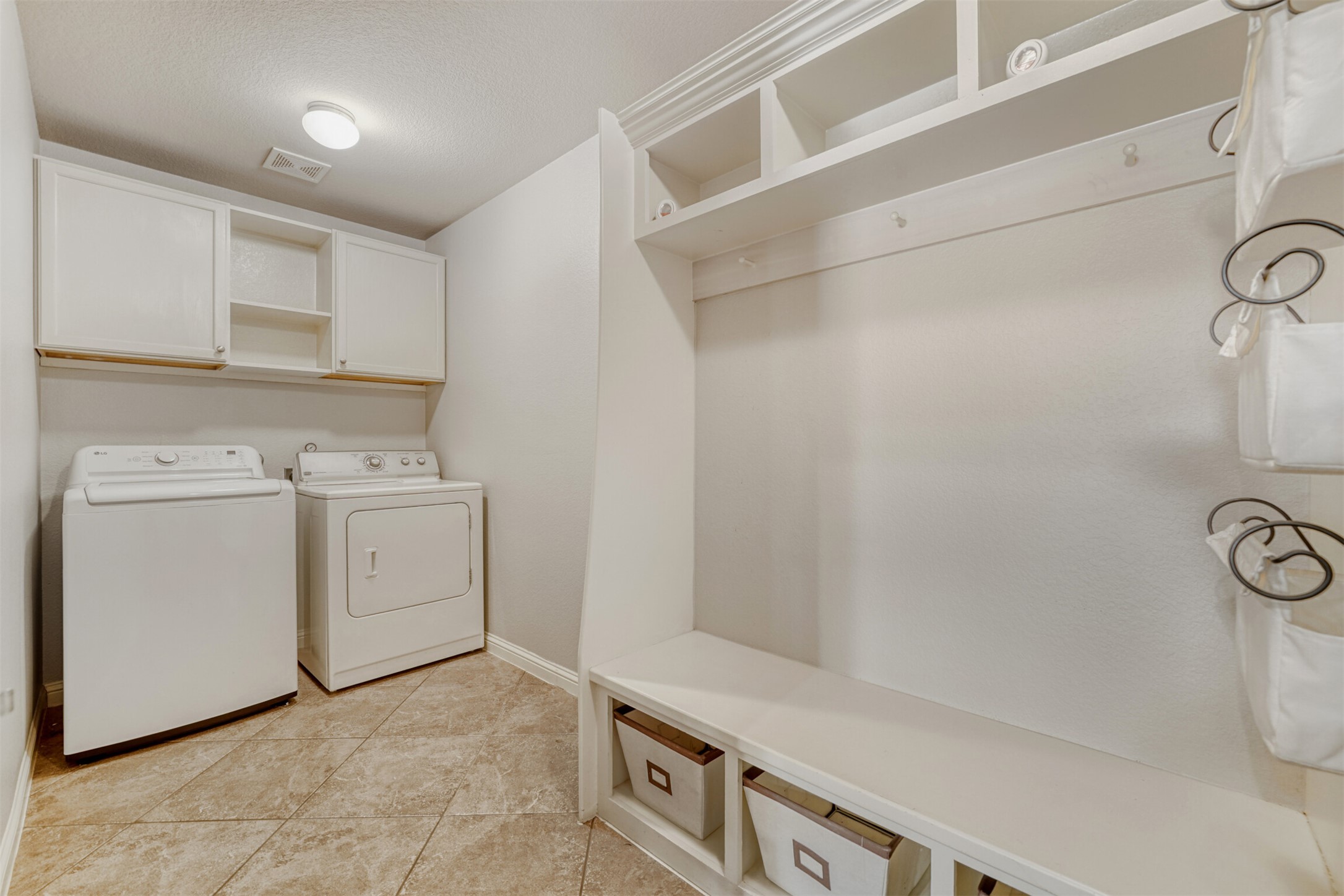 2431 Santa Barbara Loop Round Rock, TX 78665 - Photo 30 of 34 Washroom with separate washer and dryer, cabinet space, and light tile patterned floors