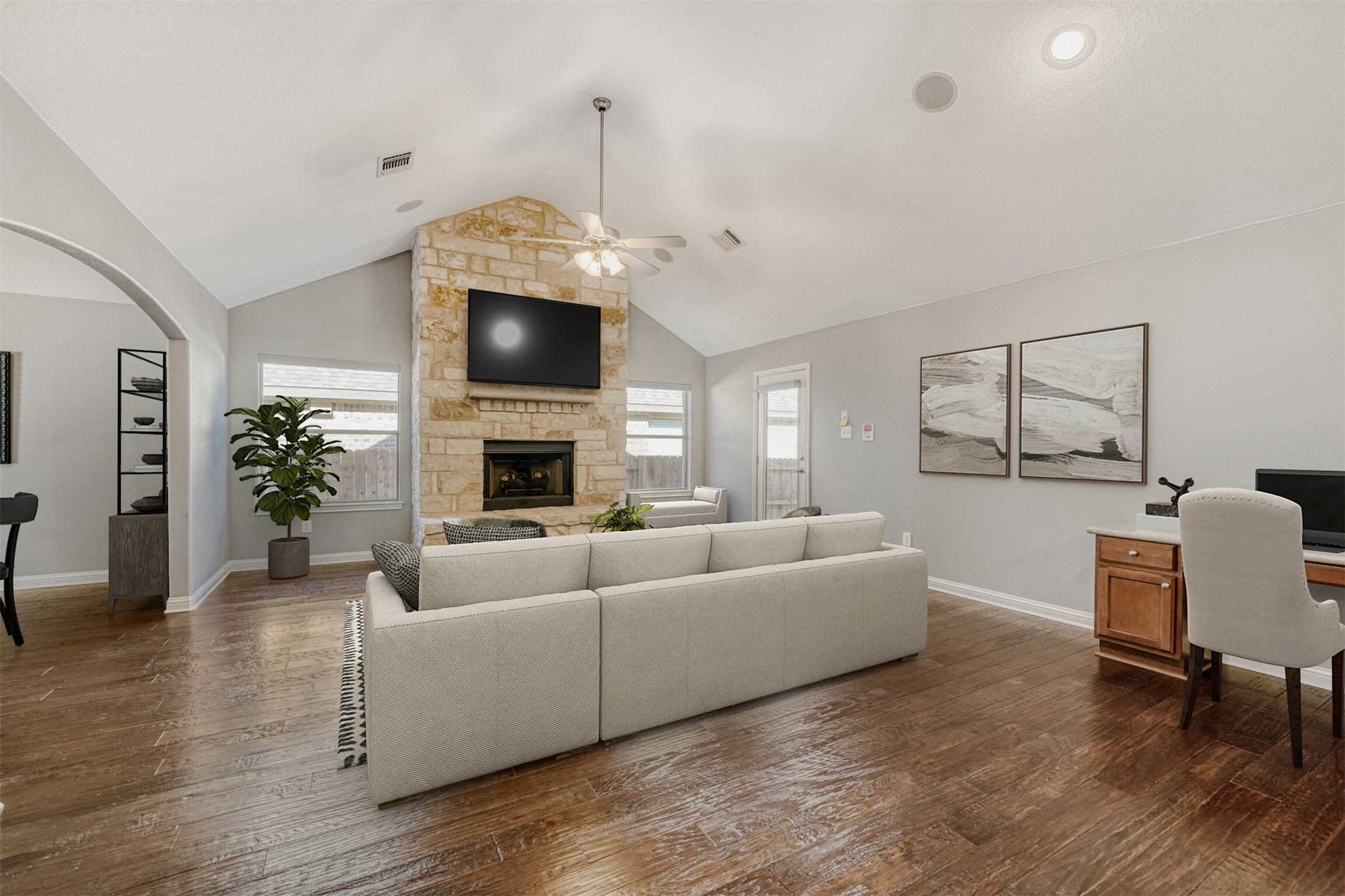 2431 Santa Barbara Loop Round Rock, TX 78665 - Photo 5 of 34 Living area featuring a stone fireplace, dark wood-style floors, lofted ceiling, a desk, and a ceiling fan
