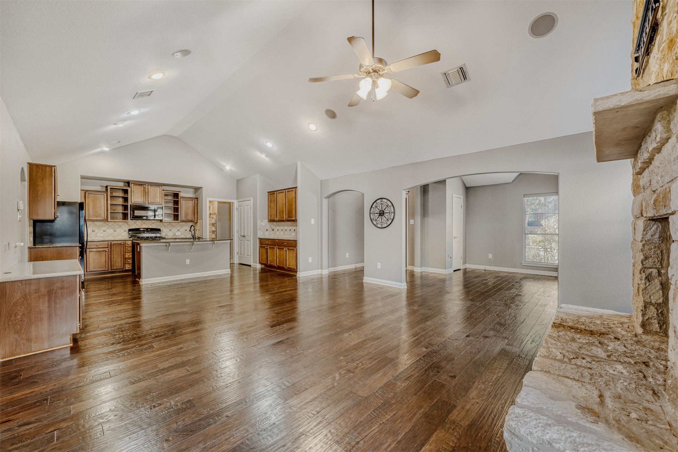 2431 Santa Barbara Loop Round Rock, TX 78665 - Photo 6 of 34 Unfurnished living room with dark wood finished floors, arched walkways, a ceiling fan, and high vaulted ceiling