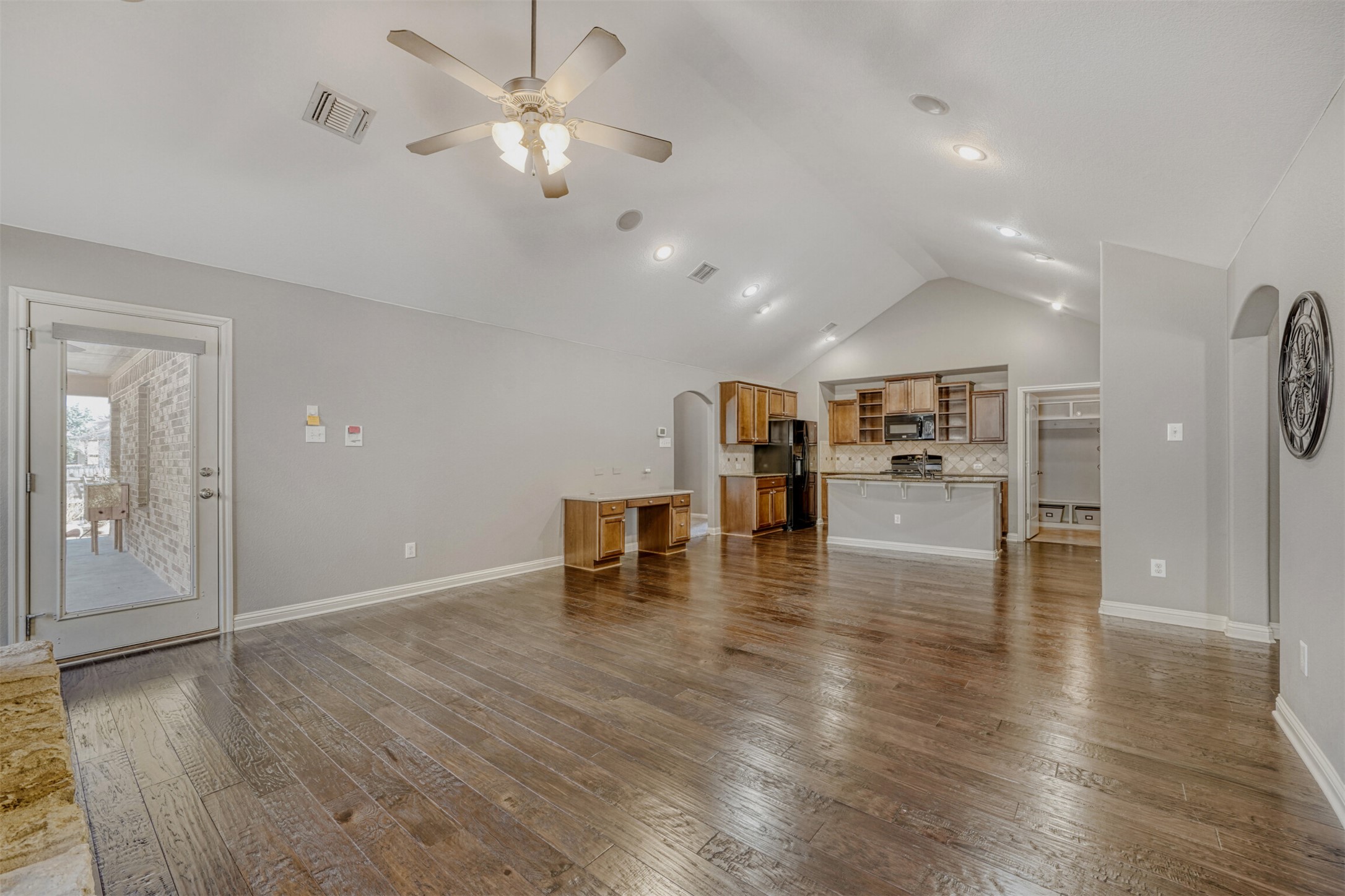 2431 Santa Barbara Loop Round Rock, TX 78665 - Photo 8 of 34 Unfurnished living room featuring arched walkways, dark wood finished floors, lofted ceiling, and ceiling fan