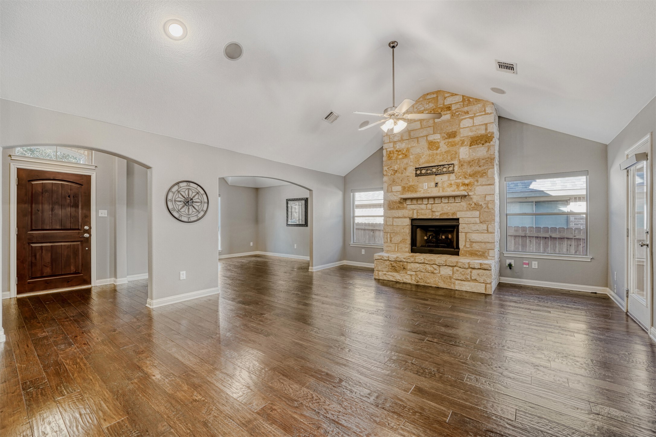 2431 Santa Barbara Loop Round Rock, TX 78665 - Photo 9 of 34 Unfurnished living room featuring a ceiling fan, a fireplace, dark wood-type flooring, and lofted ceiling