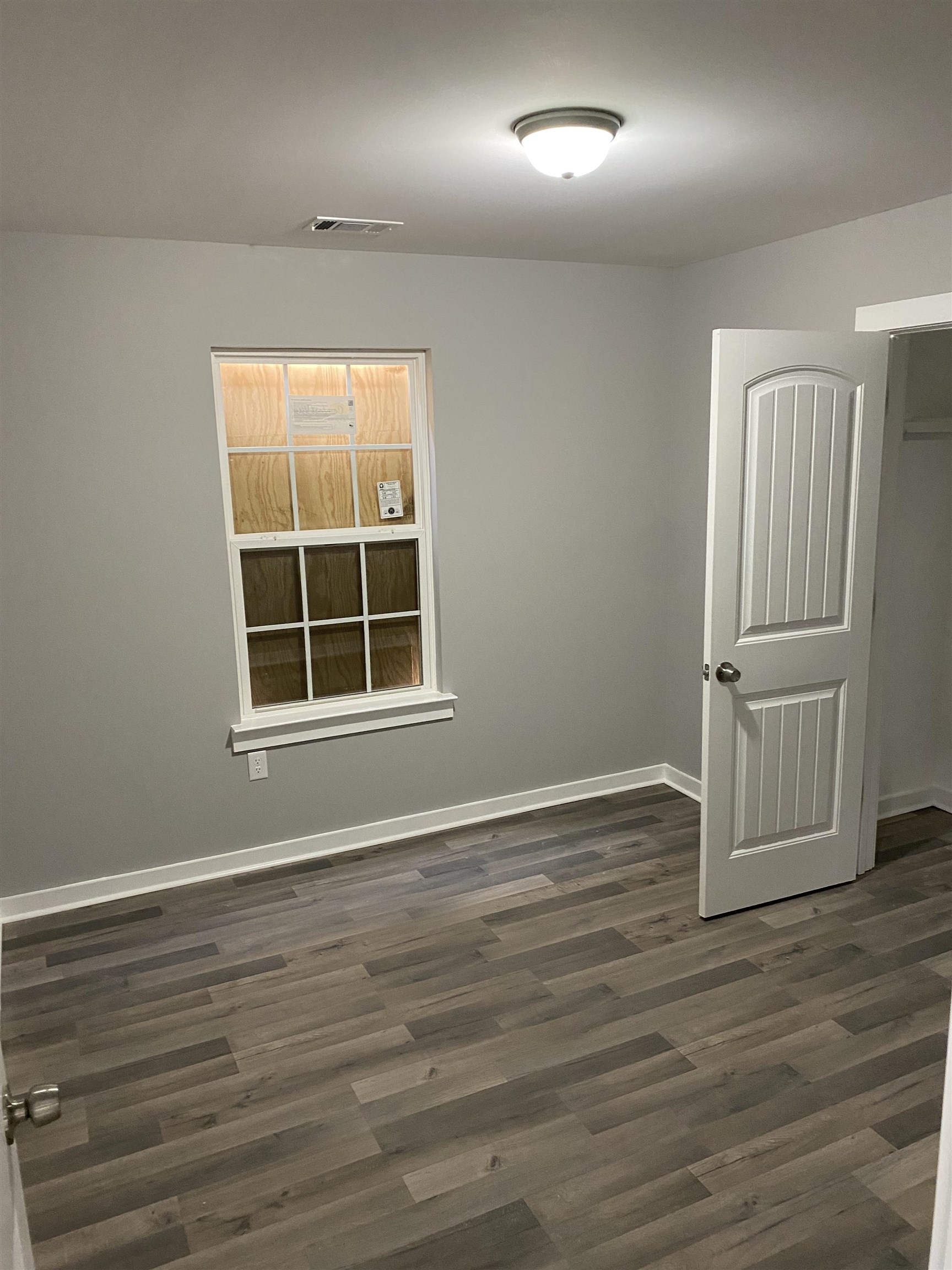 2352 Manchester Road Memphis, TN 38114 - Photo 22 of 36 a view of an empty room with wooden floor and a window