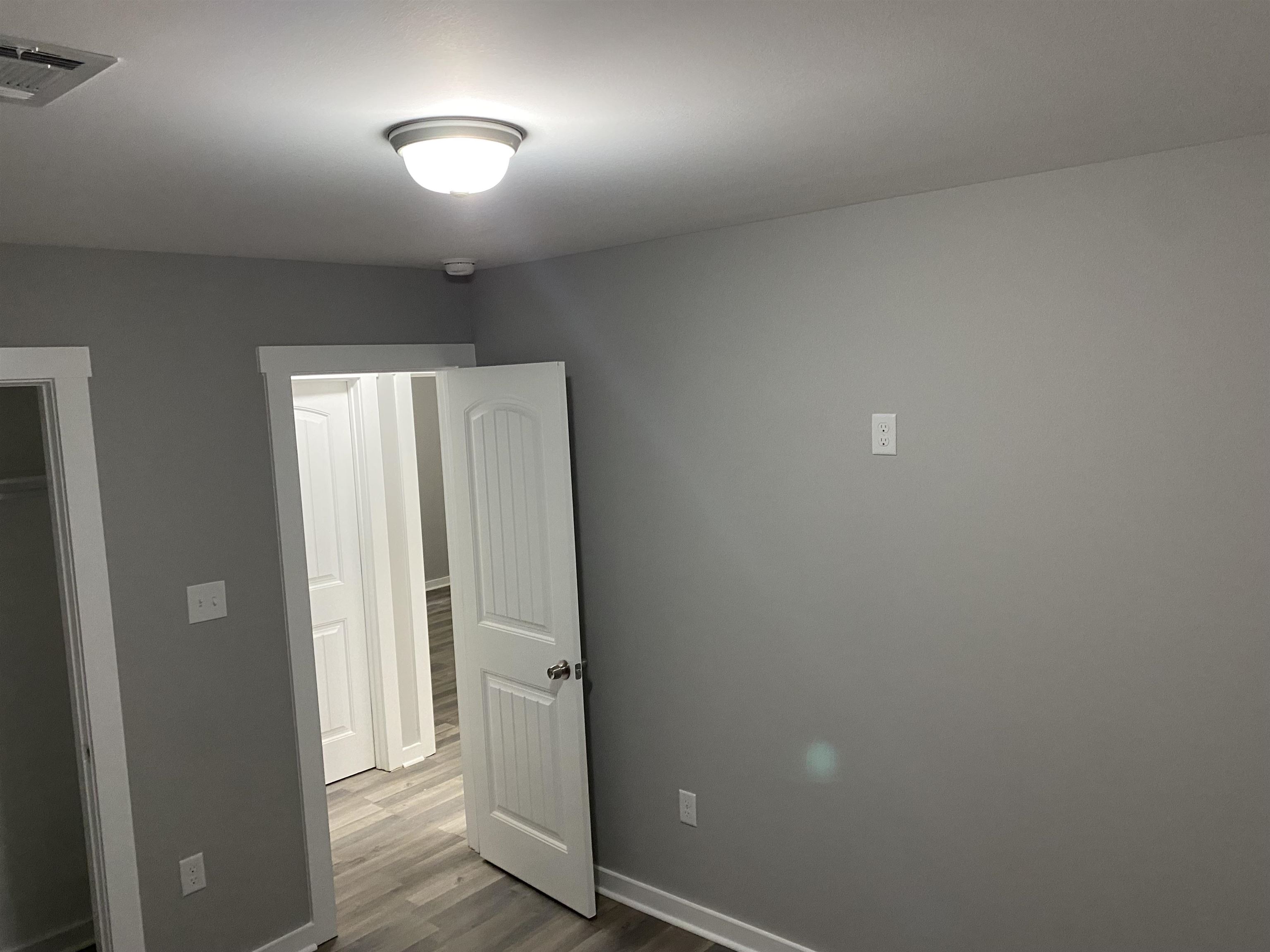 2352 Manchester Road Memphis, TN 38114 - Photo 29 of 36 an empty room with wooden floor and mirror