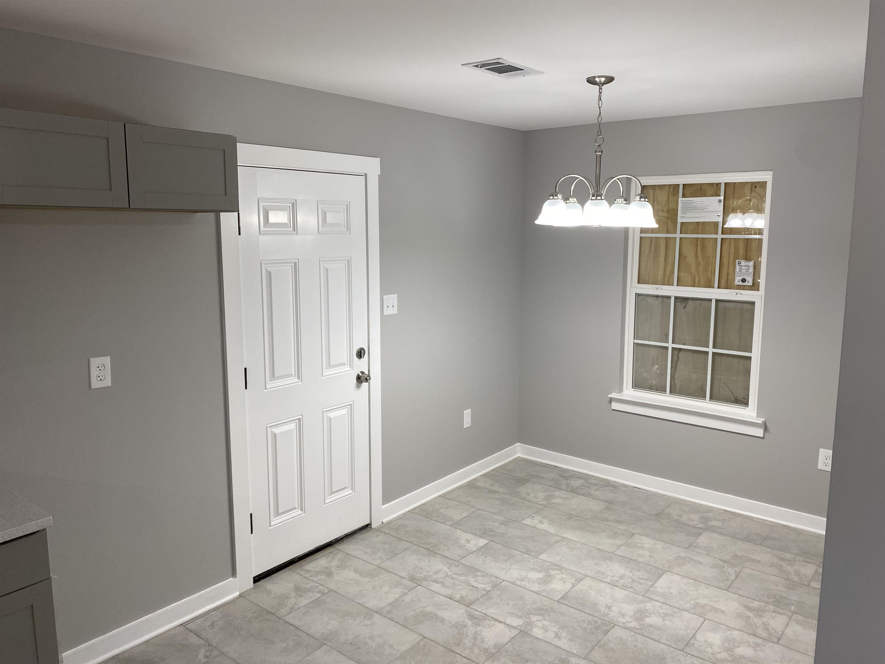 2352 Manchester Road Memphis, TN 38114 - Photo 5 of 36 an empty room with chandelier and windows