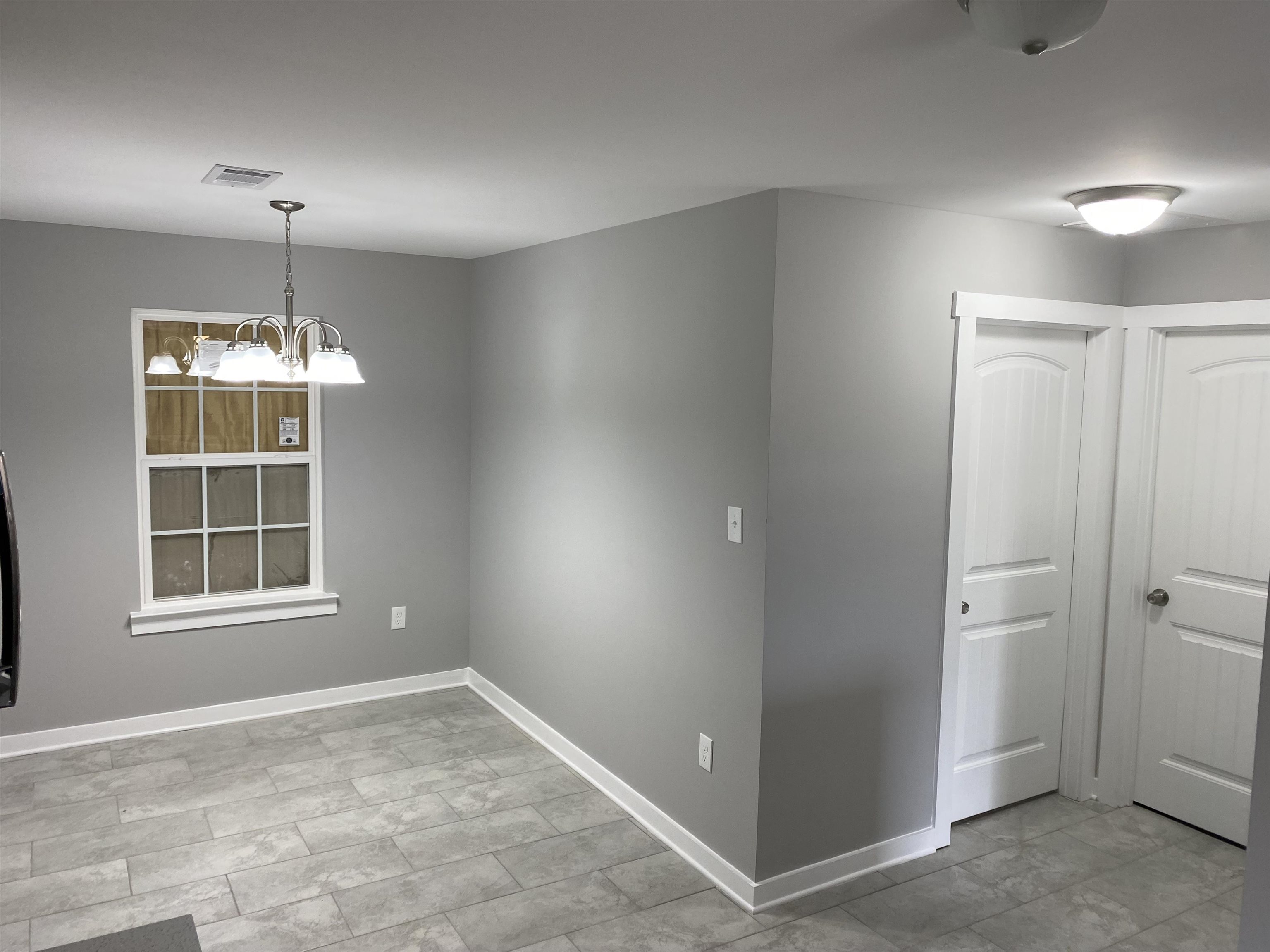 2352 Manchester Road Memphis, TN 38114 - Photo 6 of 36 an empty room with chandelier and windows