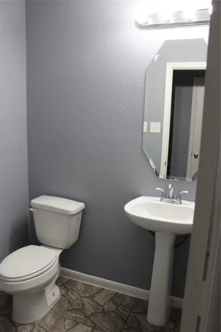 a bathroom with a toilet a sink and mirror