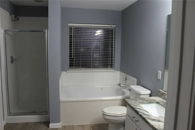 a bathroom with a granite countertop toilet a sink and a bathtub