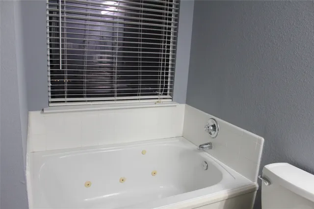a bathroom with a bathtub and a window