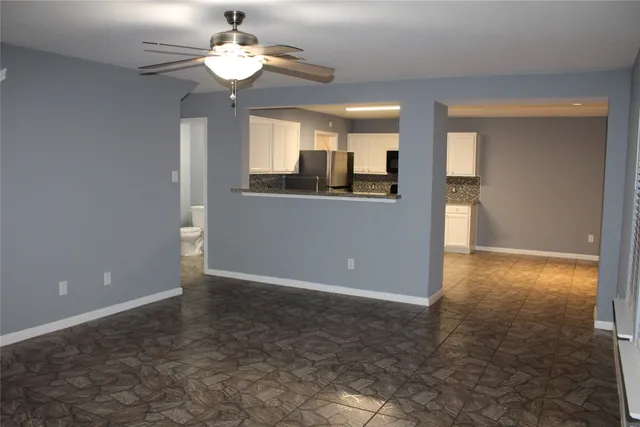 a view of a kitchen with a sink and a chandelier fan