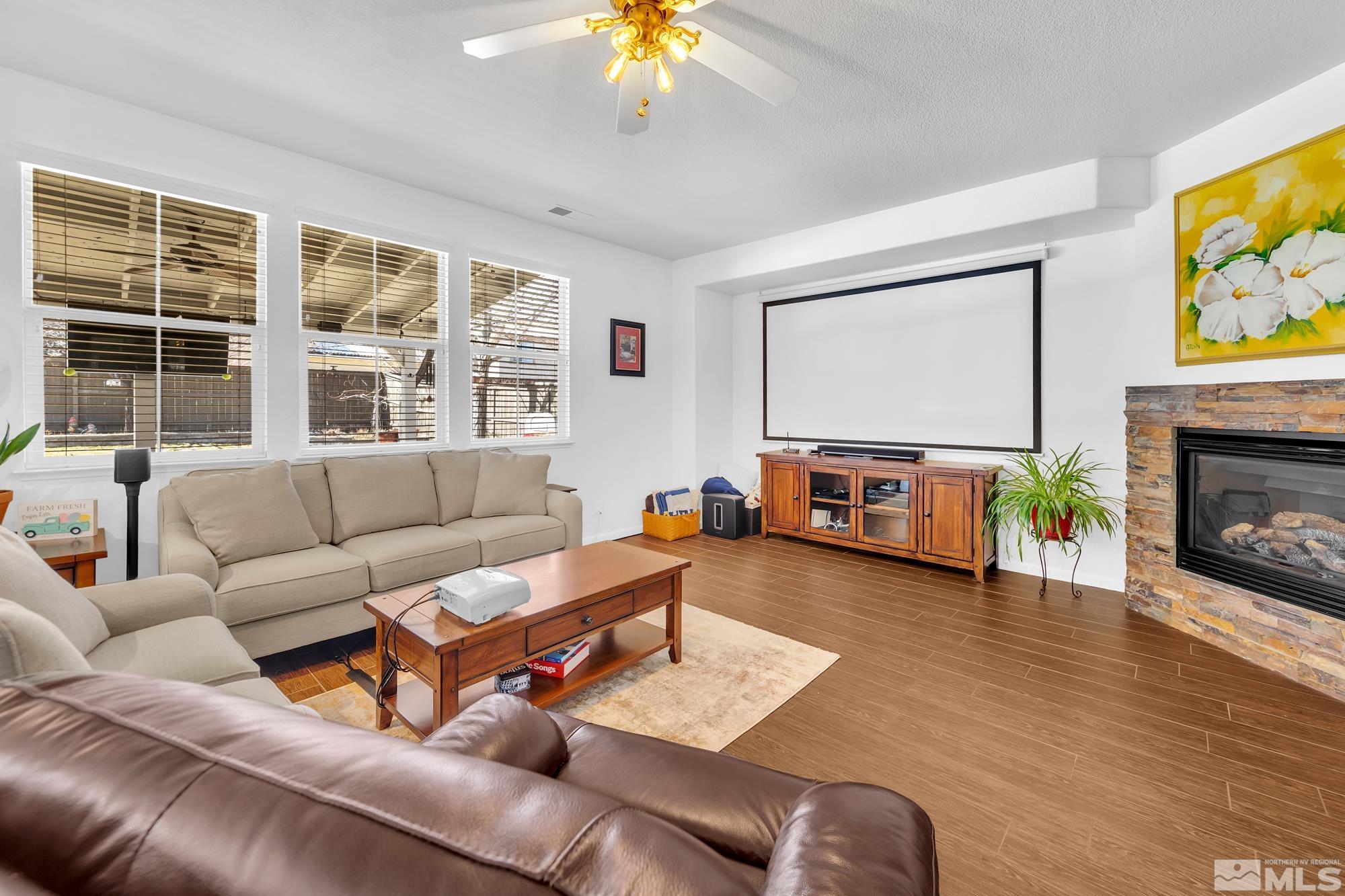 596 Needles Court Reno, NV 89521 - Photo 14 of 40 a living room with furniture a fireplace and a flat screen tv