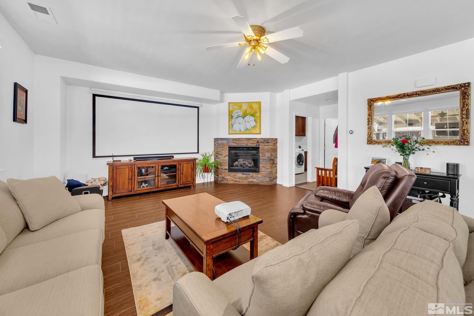 596 Needles Court Reno, NV 89521 - Photo 15 of 40 a living room with furniture a flat screen tv and a fireplace