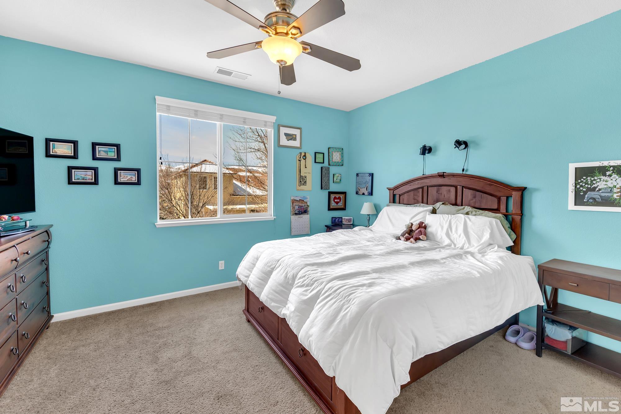 596 Needles Court Reno, NV 89521 - Photo 21 of 40 a bedroom with a bed and a flat screen tv