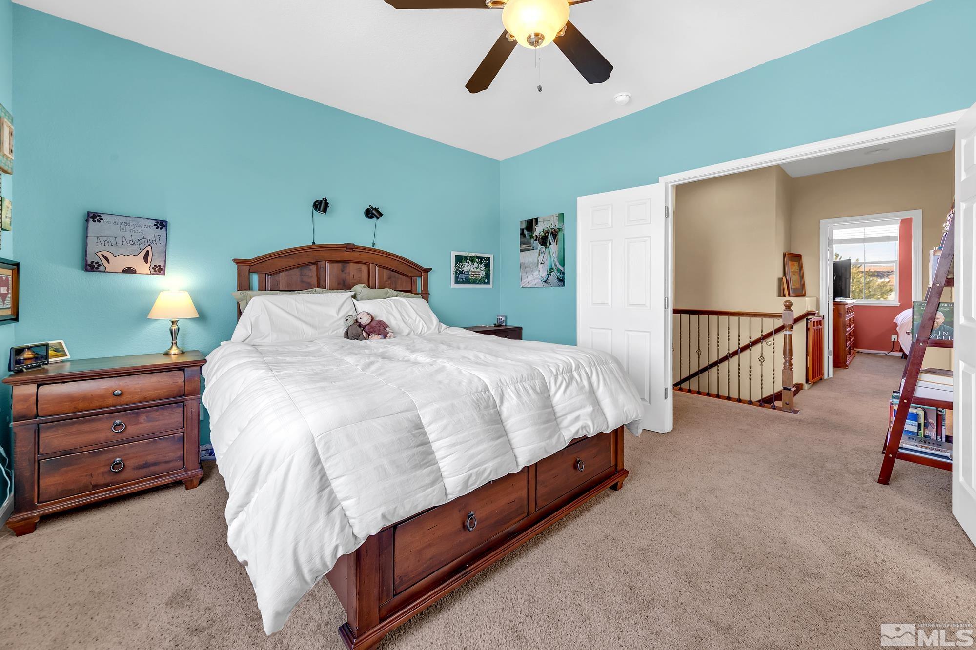 596 Needles Court Reno, NV 89521 - Photo 22 of 40 a bedroom with a bed and a chandelier