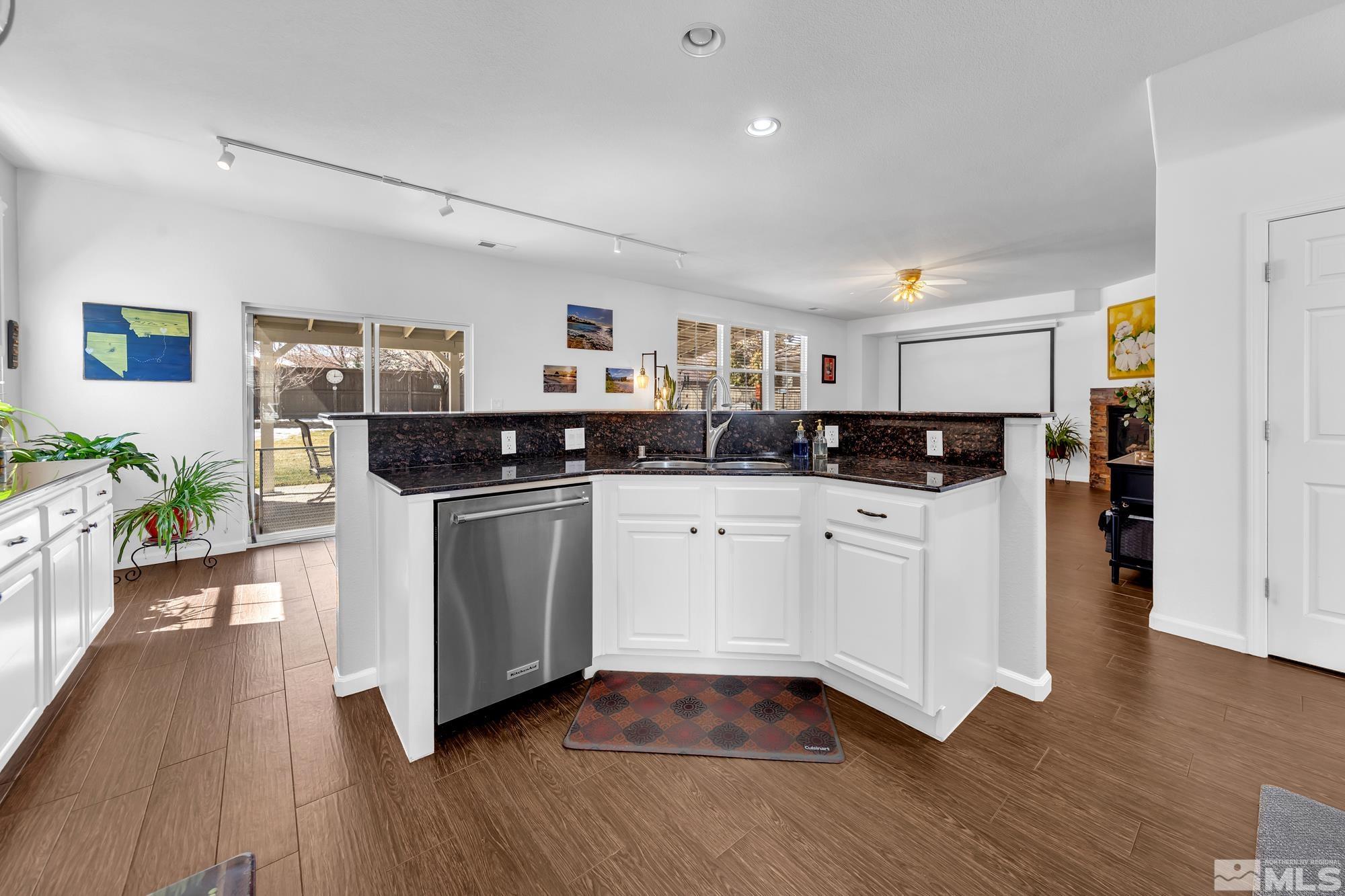 596 Needles Court Reno, NV 89521 - Photo 6 of 40 a kitchen with stainless steel appliances granite countertop a stove a sink and a refrigerator