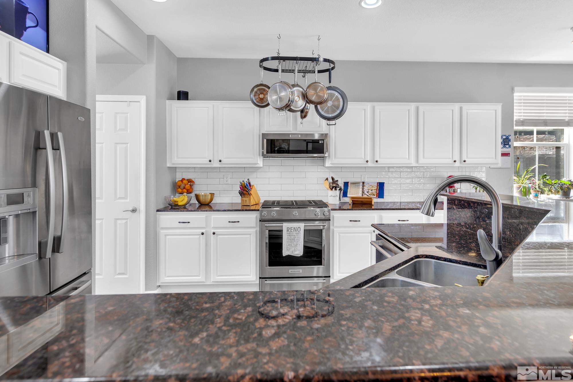 596 Needles Court Reno, NV 89521 - Photo 9 of 40 a kitchen with stainless steel appliances granite countertop a refrigerator sink and cabinets