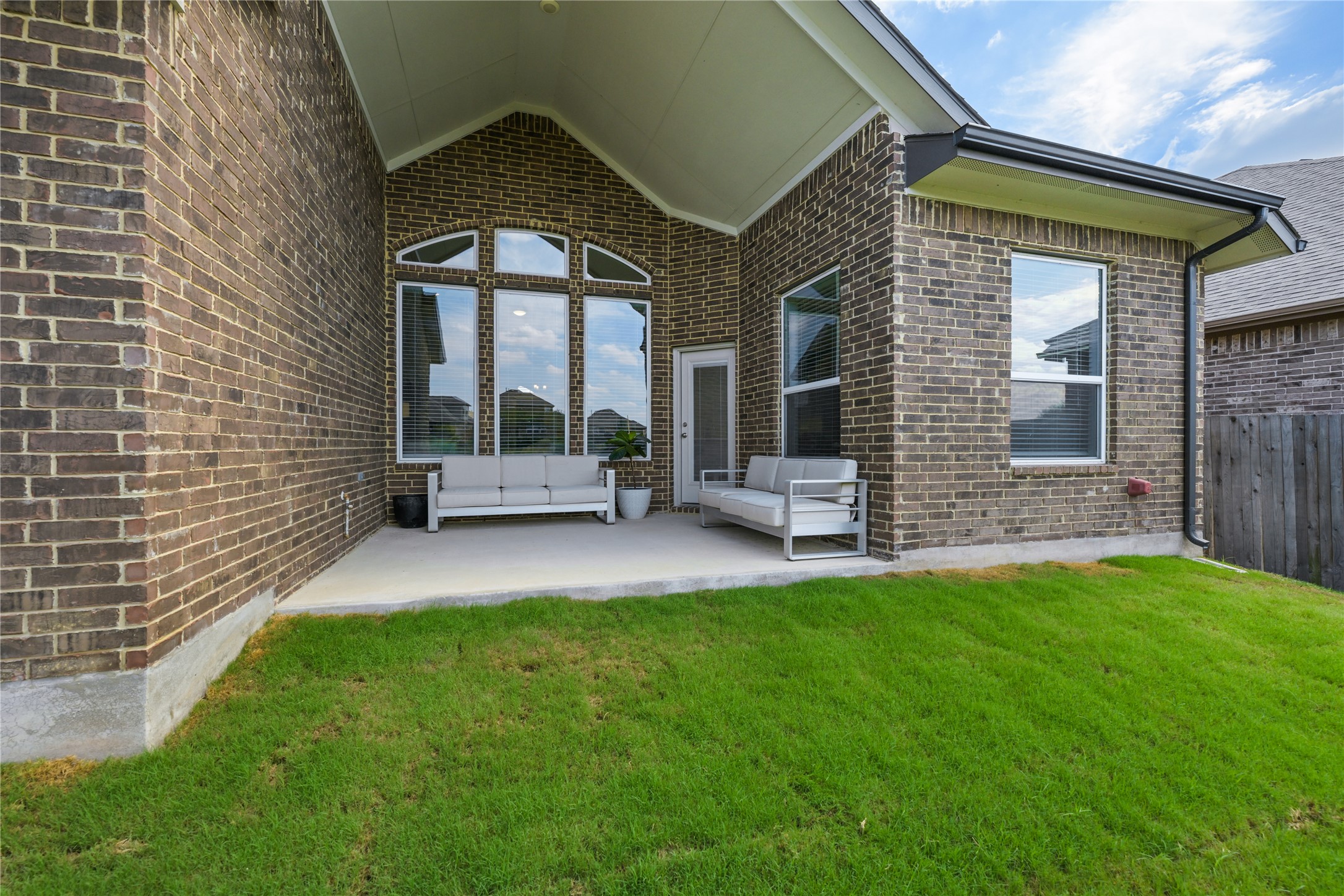 238 Wild Pecan Loop Buda, TX 78610 - Photo 27 of 31 An inviting covered concrete patio transitions seamlessly to the lush green lawn.