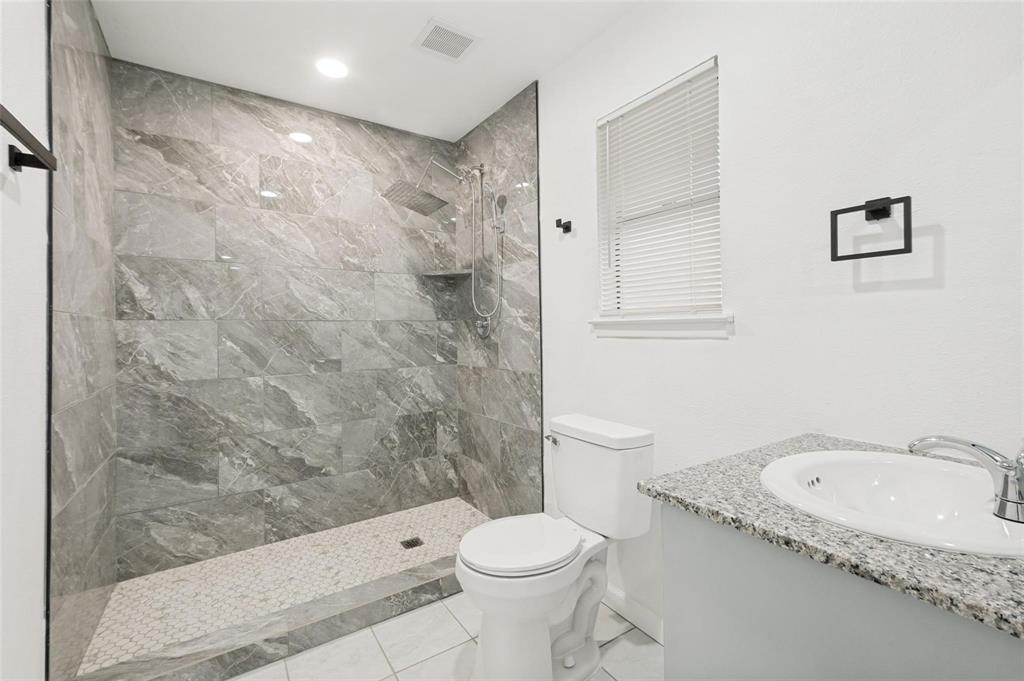 2908 Legend Road Arlington, TX 76014 - Photo 25 of 29 Contemporary bathroom featuring a large walk-in shower with gray marbled tile surround and pebble-style flooring