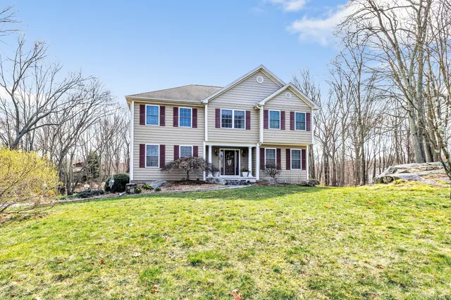 a front view of a house with a yard outdoor seating and yard in the back
