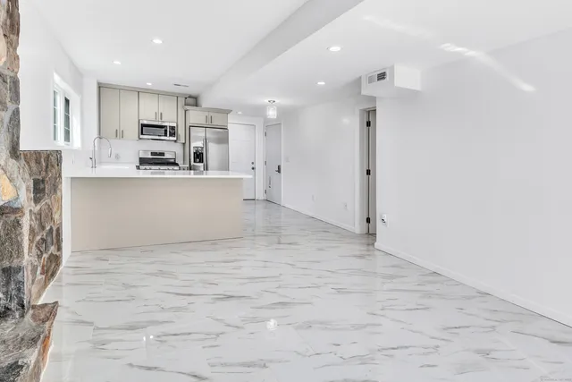 a view of kitchen with stainless steel appliances cabinets