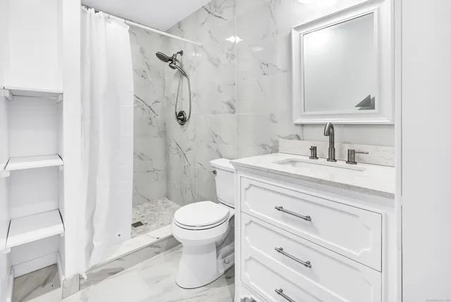 a bathroom with a sink a toilet and shower