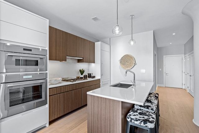 a kitchen with stainless steel appliances granite countertop a stove a sink and a microwave
