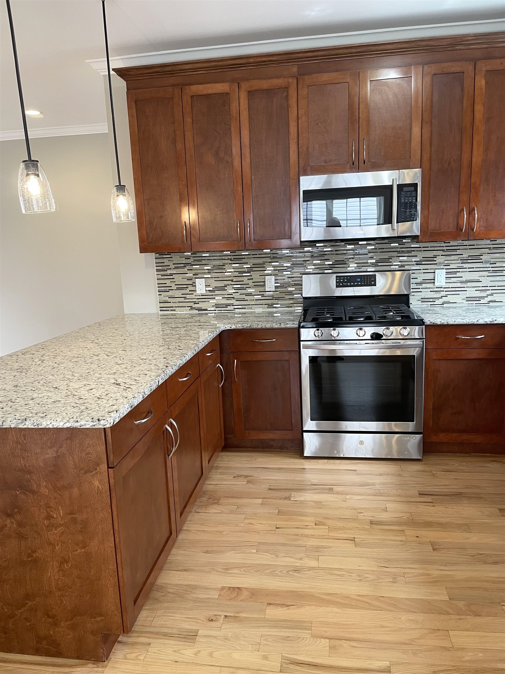 734 County Avenue, Unit A1 Secaucus, NJ 07094 - Photo 9 of 19 a kitchen with stainless steel appliances granite countertop a stove a microwave and a sink