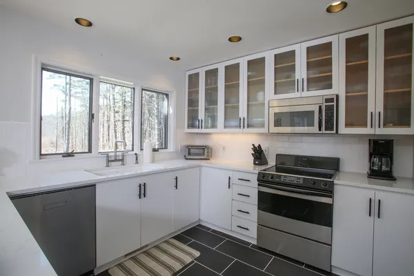 a kitchen with stainless steel appliances a dining table chairs and a refrigerator