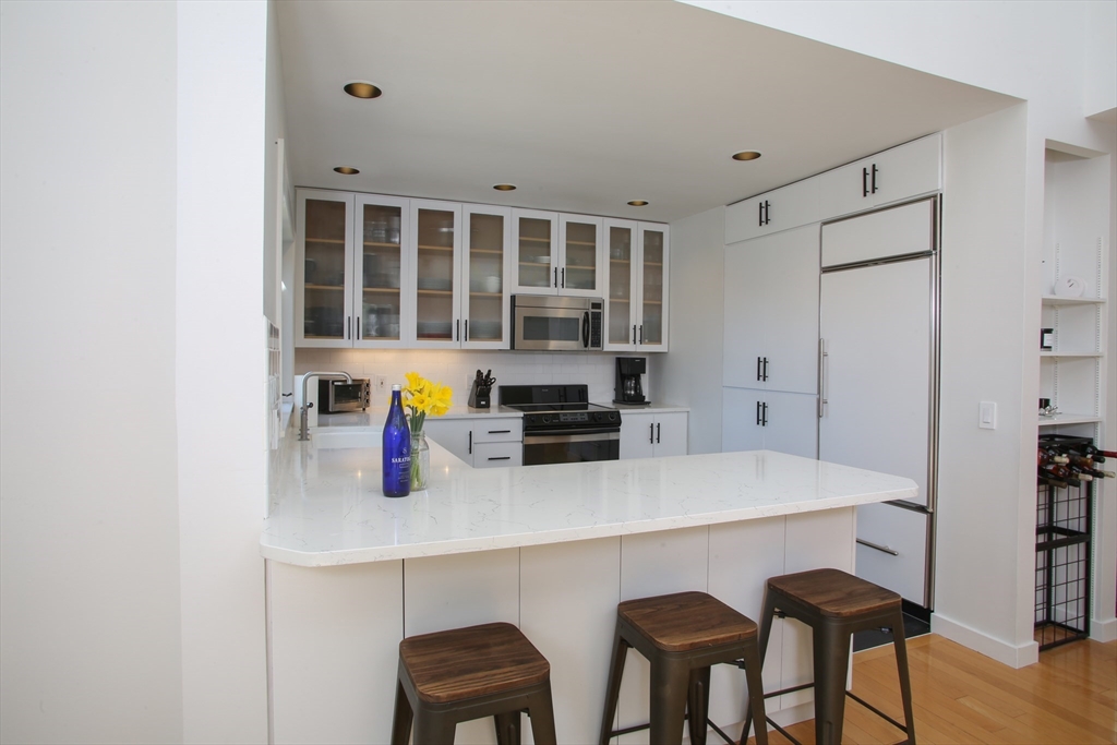 23 Cross Road Alford, MA 01230 - Photo 12 of 37 a kitchen with stainless steel appliances a dining table chairs and a refrigerator