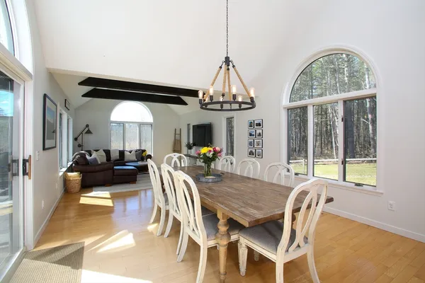 a view of a dining room with furniture wooden floor chandelier and a rug
