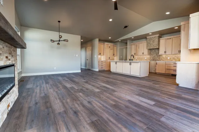 a big room with kitchen island wooden floors stainless steel appliances and cabinets